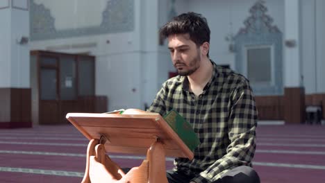 Joven-Musulmán-Leyendo-El-Corán-En-La-Mezquita