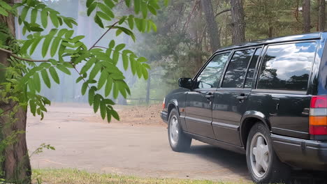 Car-with-engine-on-in-the-forest,-grey-smoke-emission,-pollution-in-nature