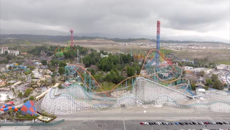 six flags magic mountain theme park in valencia, california, roller coaster rides, aerial pullback on cloudy day