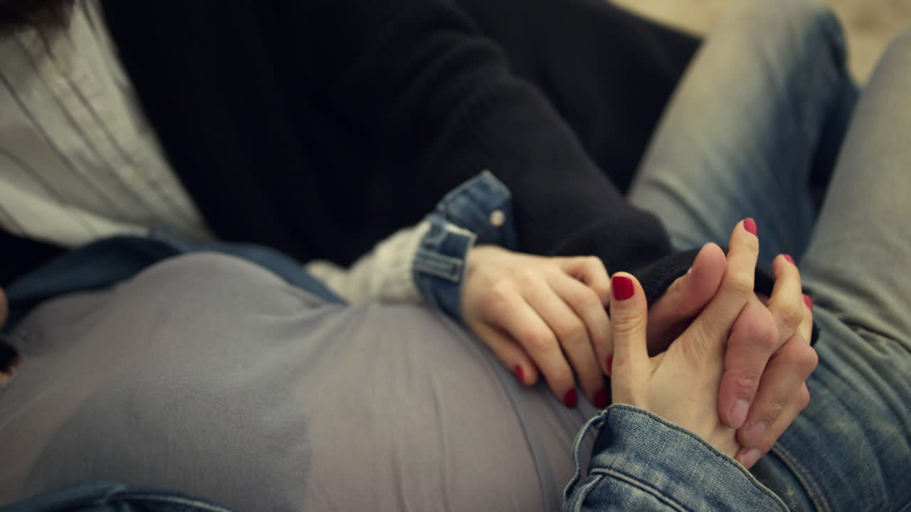 Two people relaxing beach. Multiethnic couple relaxing holding hands outdoors.
