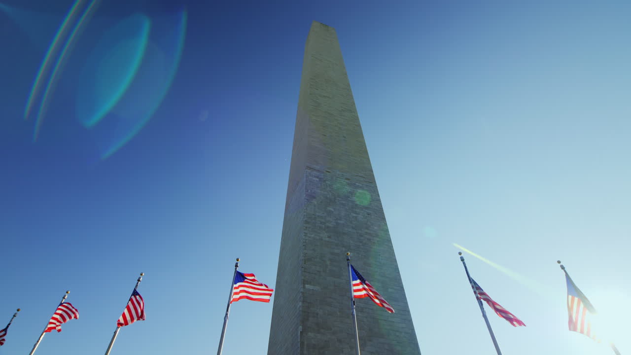 Washington Monument e bandiere americane con bagliore solare