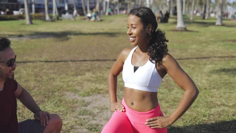 Hombre-Ayudando-A-Mujer-Con-Ejercicio-En-El-Parque