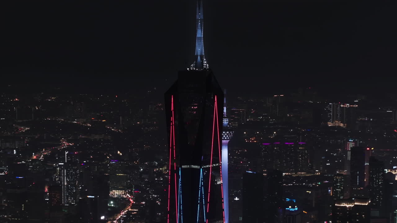 Telezoom aerial orbiting the Merdeka 118 tower, night in Kuala Lumpur, Malaysia