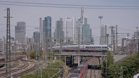 ice train crossing bridge in urban area with city skyline in daylight, clear skies