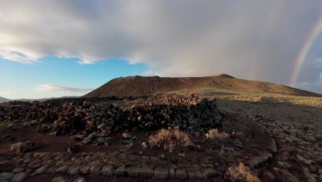 hombre caminando en el camino hacia el volcán de calderón hondo al amanecer. isla de fuerteventura, españa. fotografía de drones fpv de velocidad.