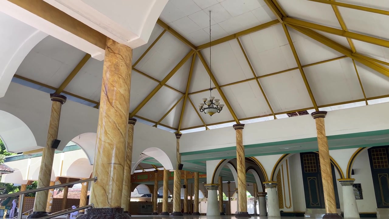 Ampio interno di una moschea con colonne ornate e soffitto a volta