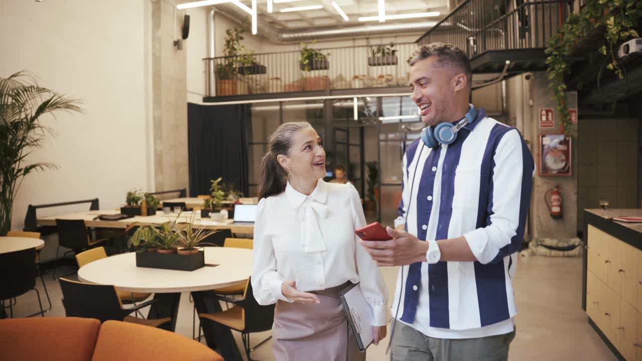 Colleghi che consultano lo smartphone vicino a un collega
