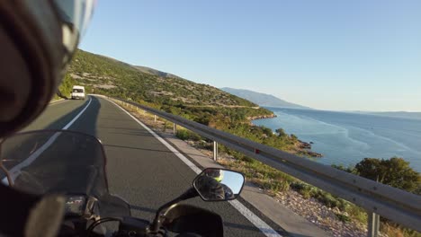 pov biker on motorcycle rides on landscape highway in croatia near sea