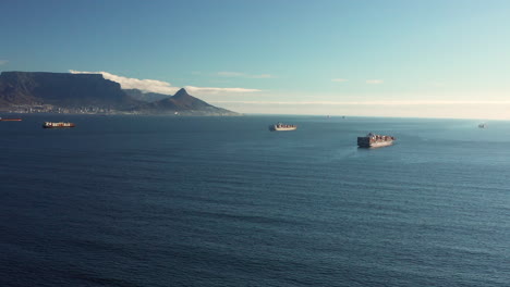 freighter ship transporting bulk of goods in the calm sea at daytime in cape town, south africa