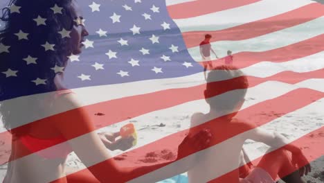 animación de la bandera de los estados unidos de américa sobre una pareja biracial con niños a orillas del mar