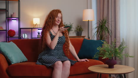 Red-hair-woman-enjoying-smartphone-call-talking,-mobile-phone-conversation-with-friends-at-home