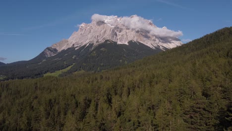 drone flying forward to spectacular scenery of germanys highest mountain the matterhorn with clouds on a sunny day in europe