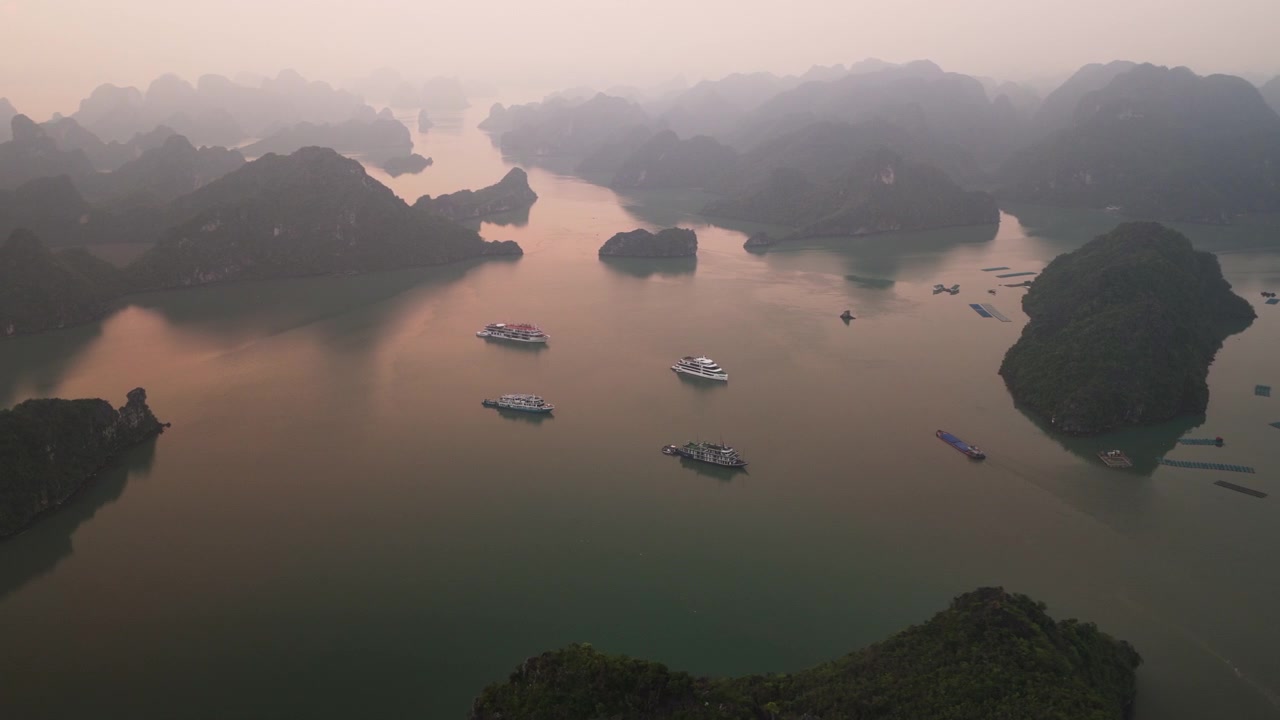 Toàn cảnh du thuyền trên mặt nước yên bình của Vịnh Hạ Long ở Việt Nam lúc hoàng hôn - Cảnh quay bằng drone