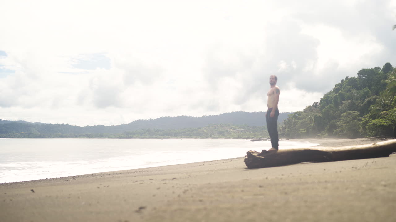 Turista caucasico in forma atletica che cammina da solo su una paradisiaca spiaggia tropicale di sabbia bianca in Costa Rica, America Centrale.
