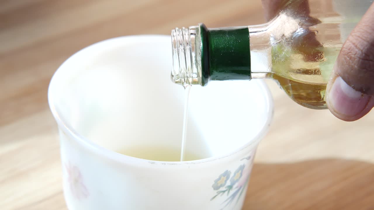 Versare olio in una tazza