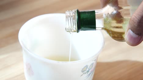 pouring oil into a cup