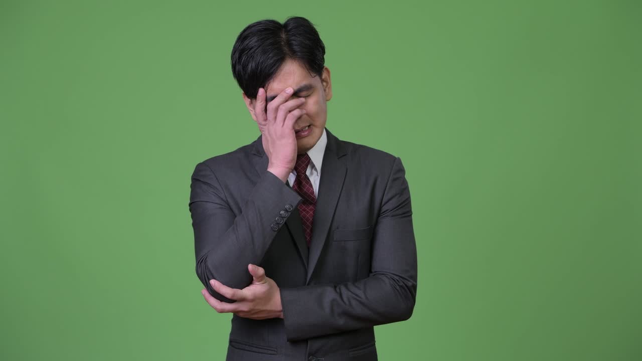 스트레스를 받는 젊은 아시아 사업가에게 나쁜 소식이 들린다.