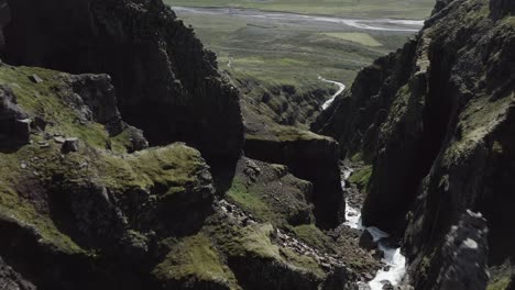 Gezackte-Felsen-In-Steiler-Schlucht-Mit-Durchfließendem-Wasser,-Antenne