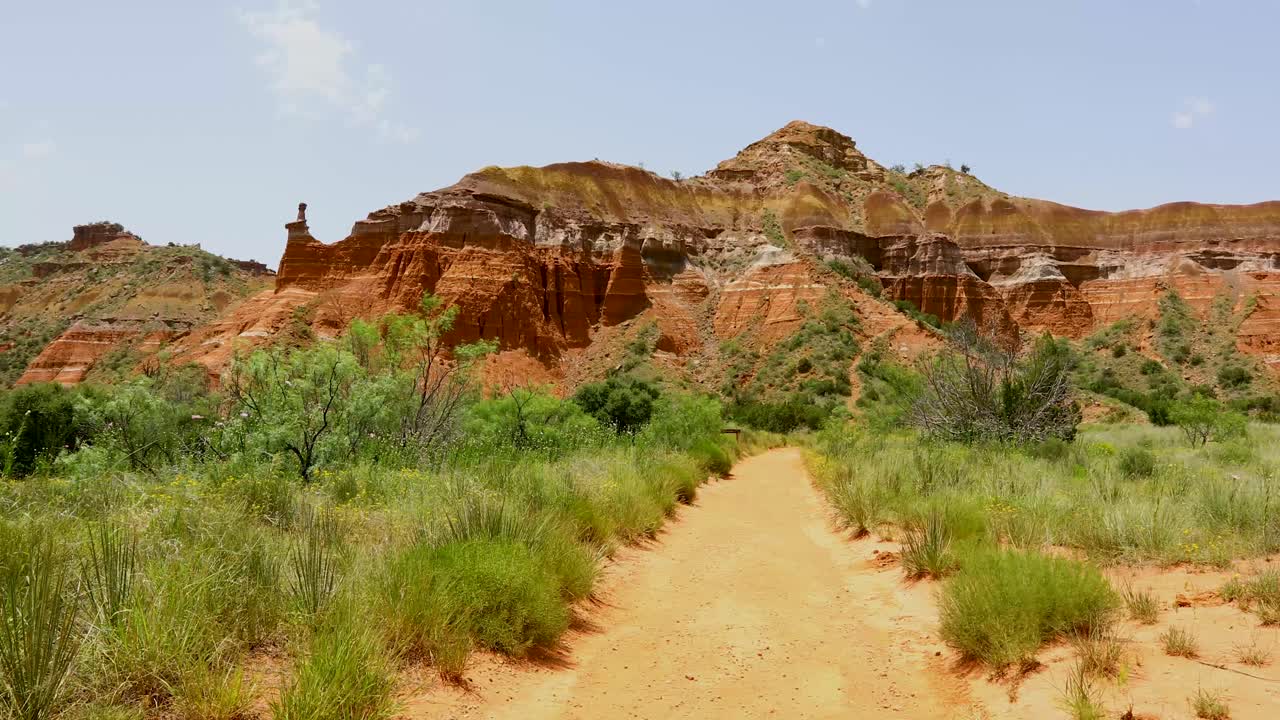 Static video of a trail in Palo Duro Canyon State Park. A mountain with unique design can be seen in the background