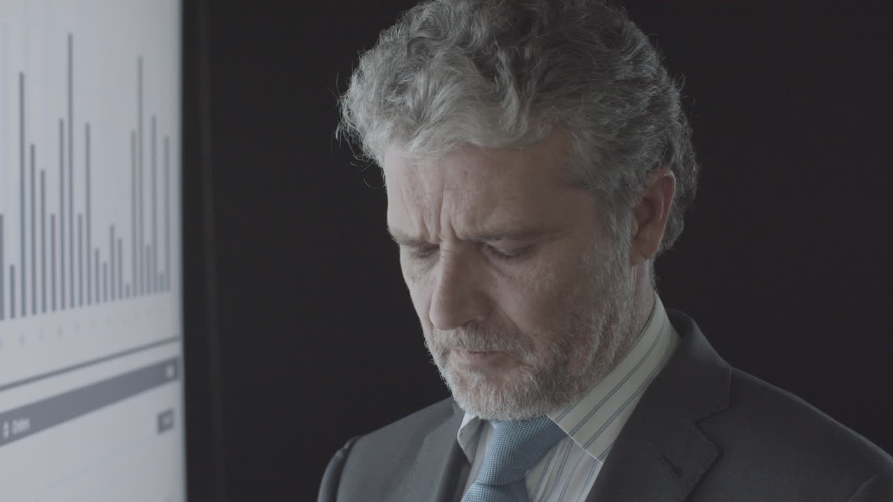 거래 차트를 분석하는 자신감 있는 성숙한 금융 전문가