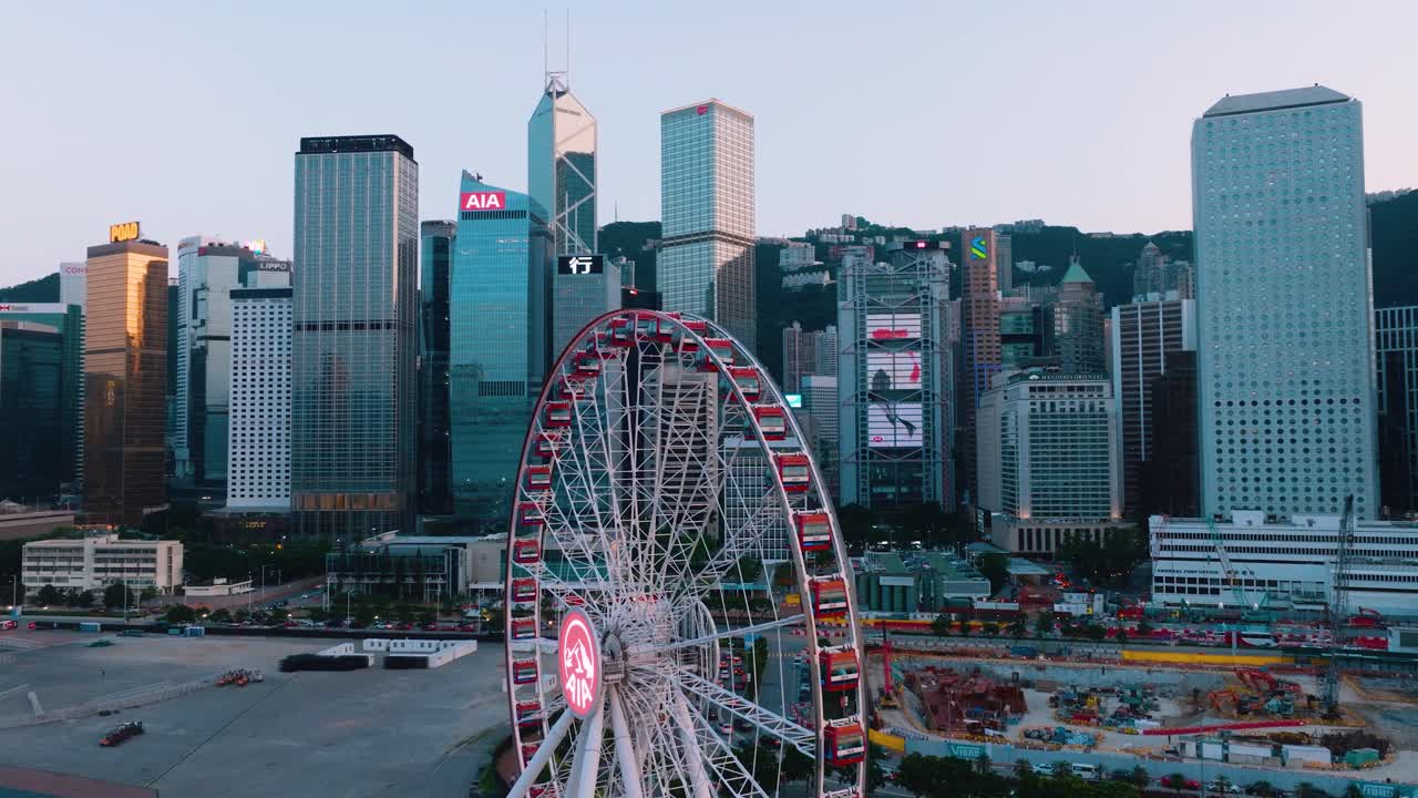 Pan drone capturing the Observation Wheel with tall skyscrapers at background in Downtown, Hong Kong.
