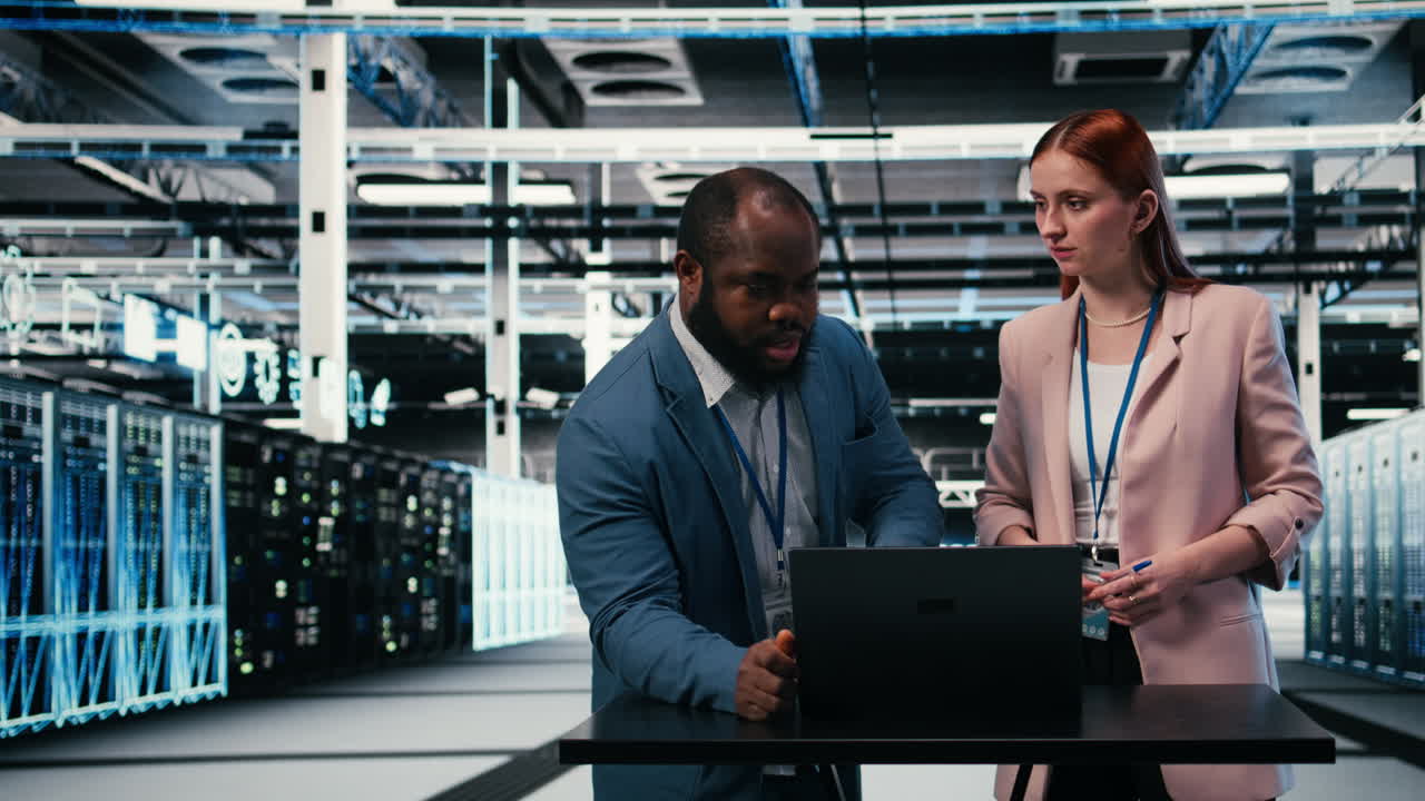 IT Engineers Discussing Data Center Operations on Laptop