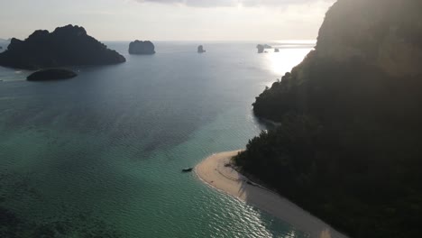 ko poda beach with its beautiful sandy beaches and clear blue waters as the reflection of the sun emerges from behind the rocks