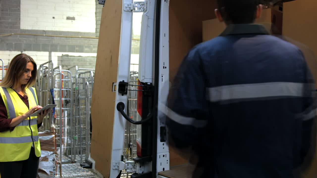 supervisor comprobando mientras el trabajador lleva una caja de cartón