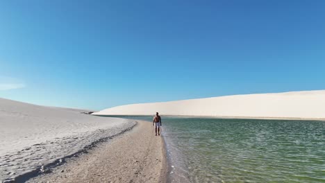 Man leaving the blue lagoon in the Lencois Maranhenses