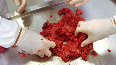 hands of butchers preparing meat ball from minced meat