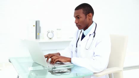 Médico-Serio-Trabajando-En-Su-Computadora-Portátil