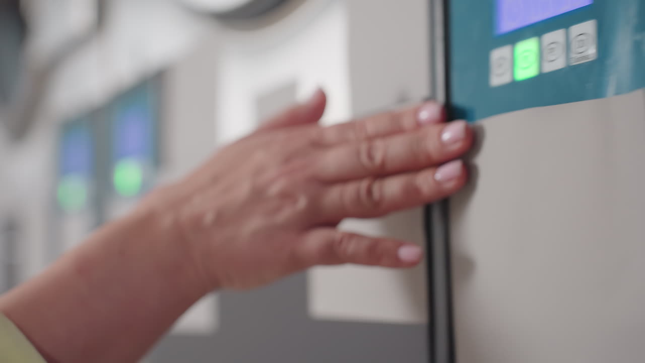 Close up staff hand glides across blur washing machine, digital controls glowing, stainless drum humming in modern laundromat, gentle motion, service pride, clean maintenance vibe, sleek metal finish