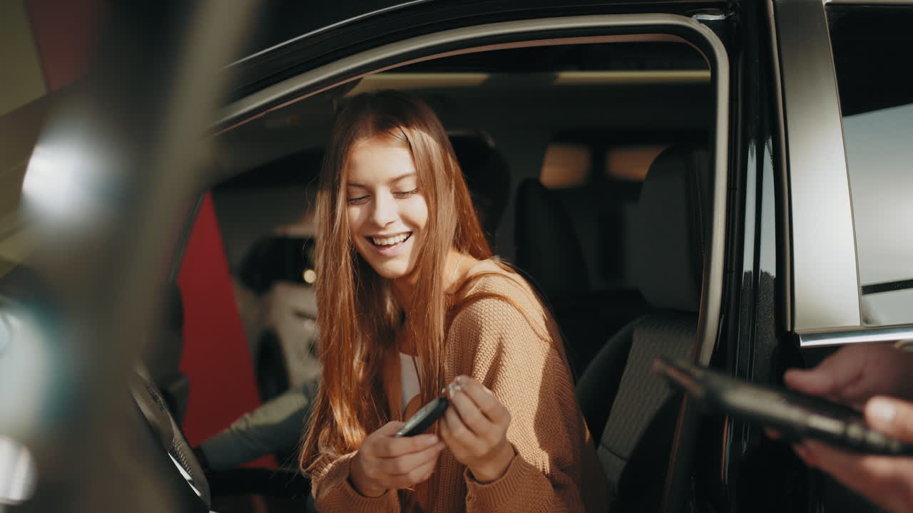 женщина получает ключи от машины в автосалоне