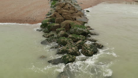 un disparo de agua de mar chocando ligeramente contra una barrera de roca en la costa sur de inglaterra.