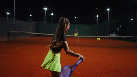 woman playing tennis at night