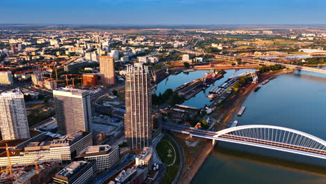 modern cityscape of bratislava, slovakia. drone footage descending above the danube river close to the appolo bridge