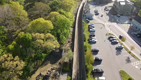 Aerial-drone-flyover-shot-of-empty-American-railroad-track-in-Hingham,-Massachusetts