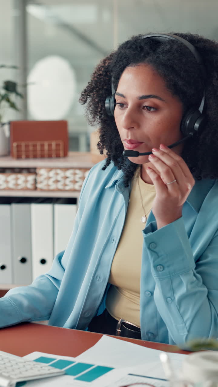 Donna con cuffie che parla e digita al computer in ufficio