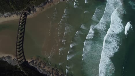 Birds-eye-drone-shot-of-Wilderness-beach-in-South-Africa---drone-is-descending-over-the-old-railway-bridge