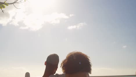 couple sitting together on a bench in the beach 4k