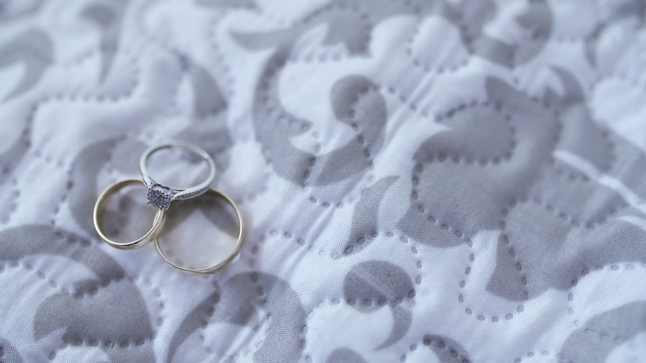 Diamond Engagement Ring and Gold Wedding Bands on Fabric