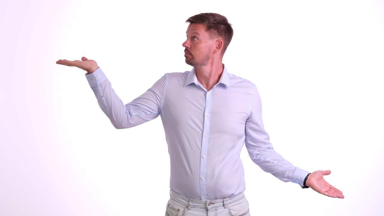 Giovane uomo pensieroso allarga le mani, prendendo una decisione difficile.