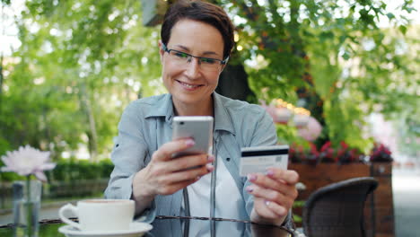 woman paying with credit card at cafe