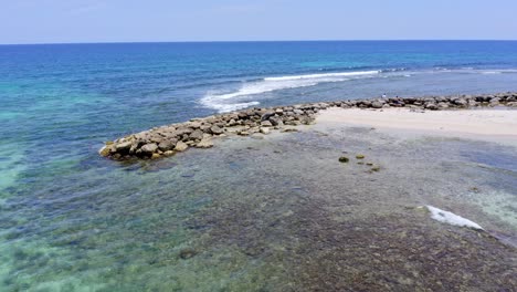 rocky breakwater on caribbean shoreline to prevent beach erosion