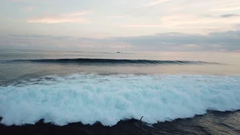 Olas-Aéreas-De-4k-Que-Se-Estrellan-Sobre-Los-Surfistas-En-El-Agua,-Lombok,-Indonesia