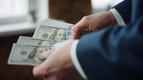 Man-hands-calculating-dollar-banknotes-close-up.-Boss-counting-american-currency