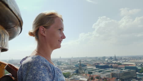 the woman admires the view from a height to copenhagen it stands on top of the church of the savior