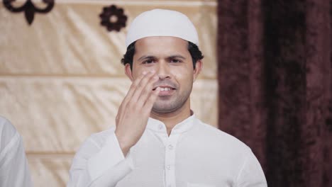 Indian-man-greeting-by-adab-and-smiling-to-the-camera