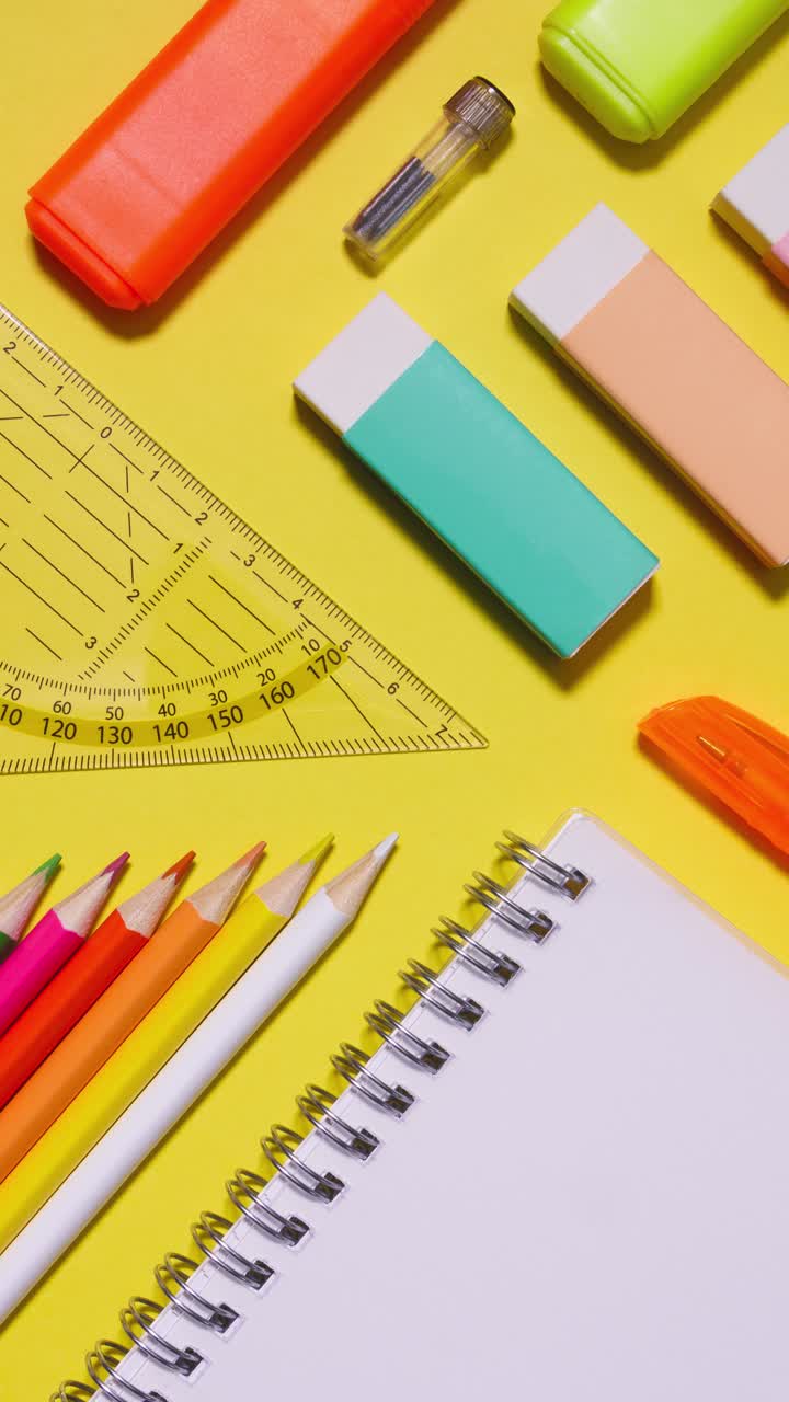 Portrait stop motion of colorful school stationery on yellow background