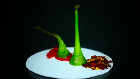 chili peppers on a white plate rotating with black background - close up